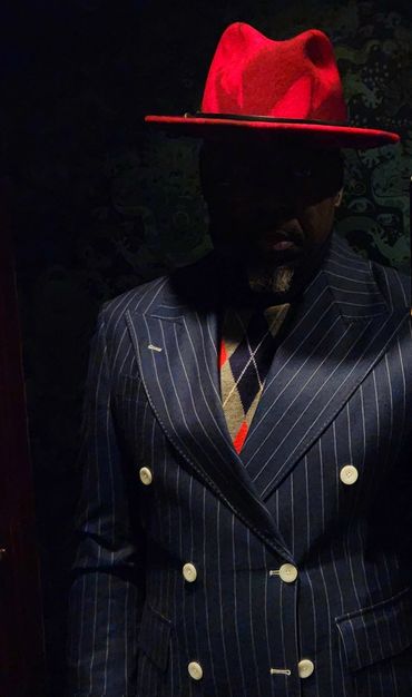 Midnight navy pinstripe double-breasted suit with wide peak lapels and bold contrast buttons.