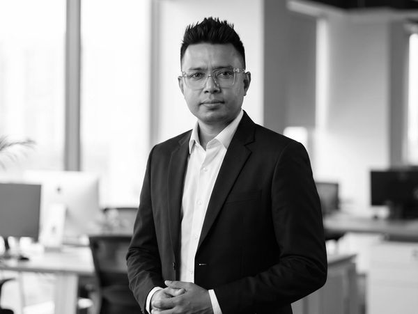 Professional man in a suit posing confidently in an office setting.