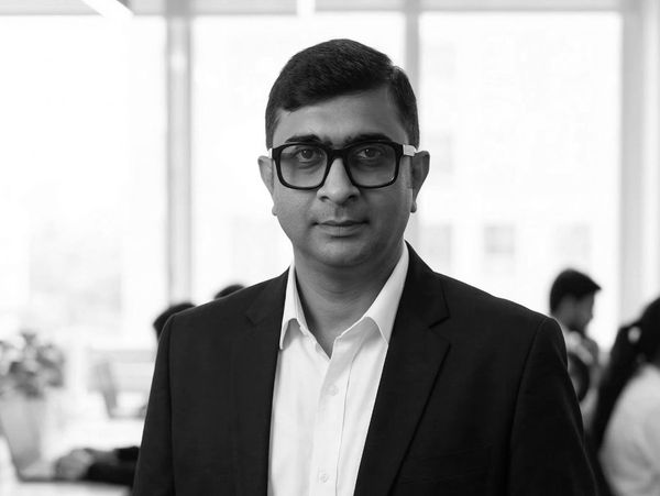 Professional man in glasses and suit in an office setting.