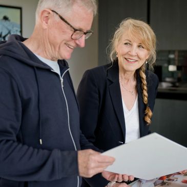 An elderly man and woman reviewing documents together indoors.