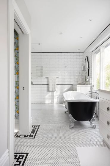 Elegant bathroom with a black clawfoot tub and white tile walls.