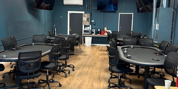 Empty poker room with tables and chairs.