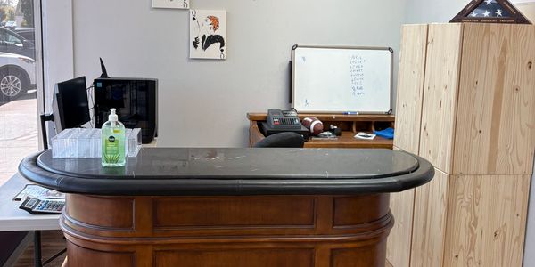 Empty office desk with sanitizer and a whiteboard in the background.