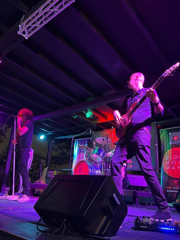 Live band performing on stage with colorful lighting.