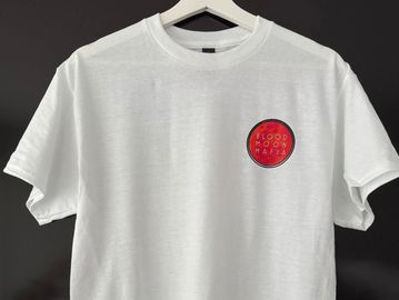 White t-shirt with a small red circular logo.