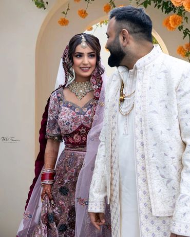 A bride and groom in traditional attire share a joyful moment.