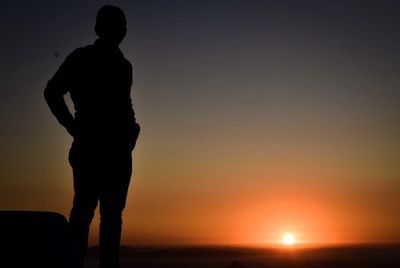 a person standing and a sunset view in the background 