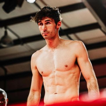 Young shirtless man with athletic build in a gym setting.