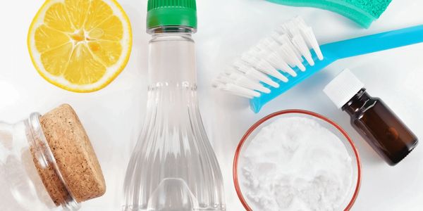 Deep cleaning supplies include a blue scrub brush, a lemon wedge, a green sponge, and baking soda.