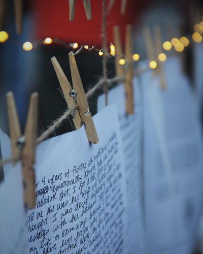 Handwritten letters clipped on a string with clothespins and fairy lights in the background.