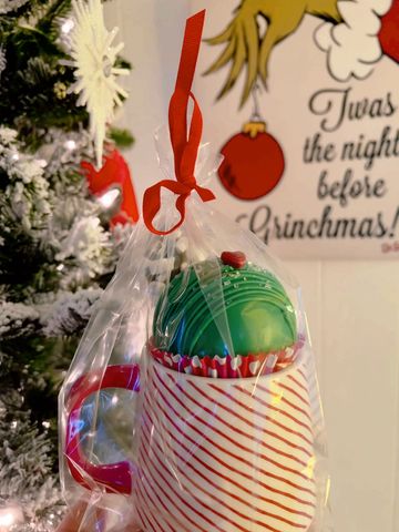 Ceramic Mug with Grinch Themed Hot Cocoa Bomb. 