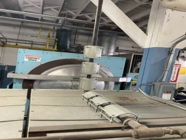 Industrial machinery with arm-like mechanisms in a factory setting.