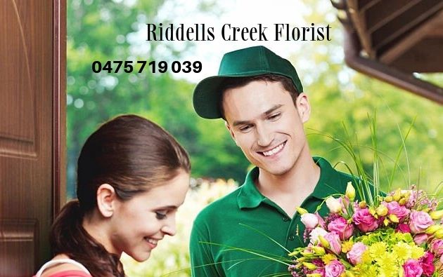 Driver is handing  Flower delivery to customers who is happy to receive flowers to her home .