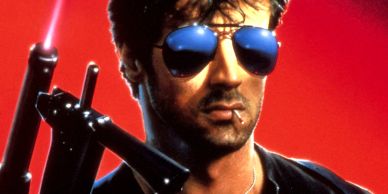 Man in sunglasses holding a gun with a red background.