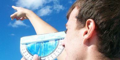 Person measuring angle of raised arm with a protractor.