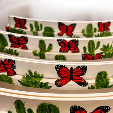 Decorative white plates with red butterflies and green cactus designs.