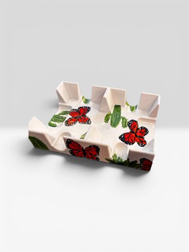 Decorative stand with red butterfly designs on a white base.