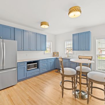 Modern kitchen with blue cabinets and wooden floor.