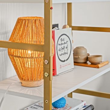 Cozy lamp lighting a shelf with books and tea set.