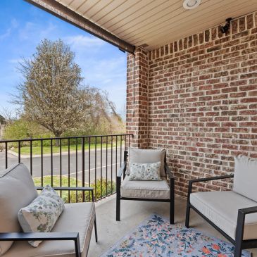 Cozy outdoor seating area on a brick balcony.