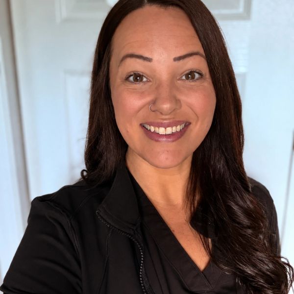 Image of lady smiling in black scrubs
