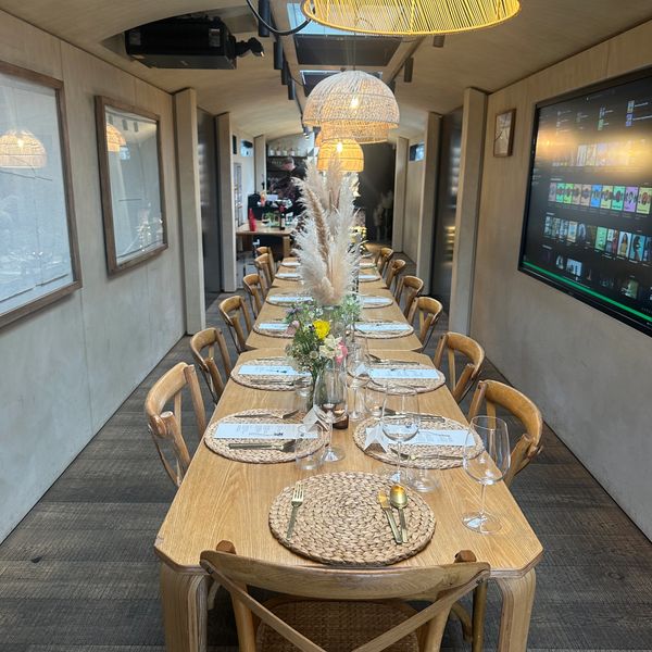Elegant long dining table set for a meal in a cozy room with warm lighting.