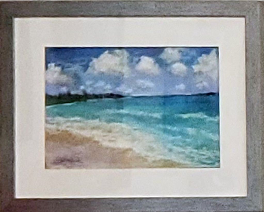 Framed painting of a beach with waves and a cloudy sky.