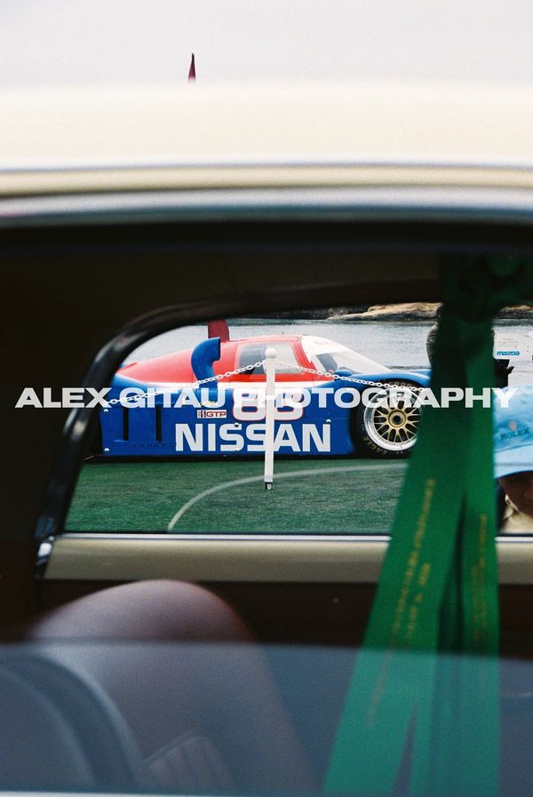 View of a Nissan race car through a car window.