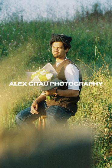 Man holding flowers in a field during golden hour.