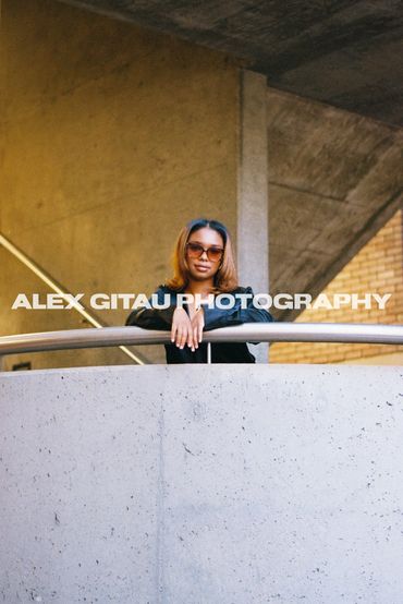 Young woman posing on staircase in downtown city setting. 