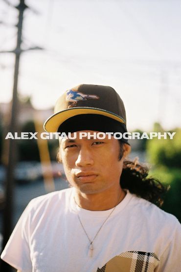 Portrait of man in a cap on balcony during golden hour.