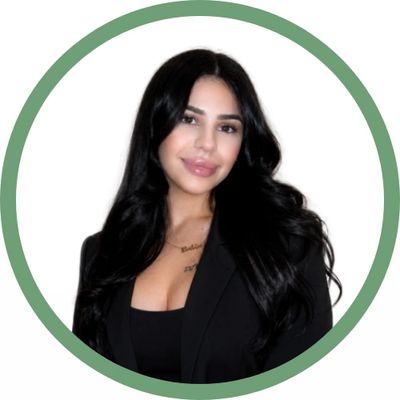 Smiling woman with long black hair wearing a black blazer and top.