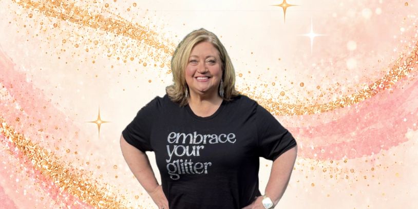 Woman smiling, wearing a shirt that says 'embrace your glitter'.