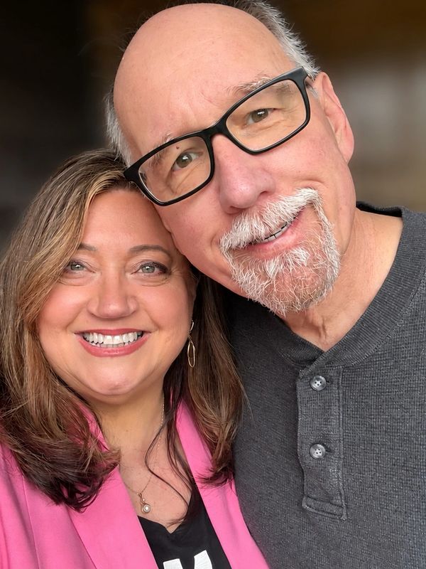 Smiling middle-aged couple taking a close selfie together.