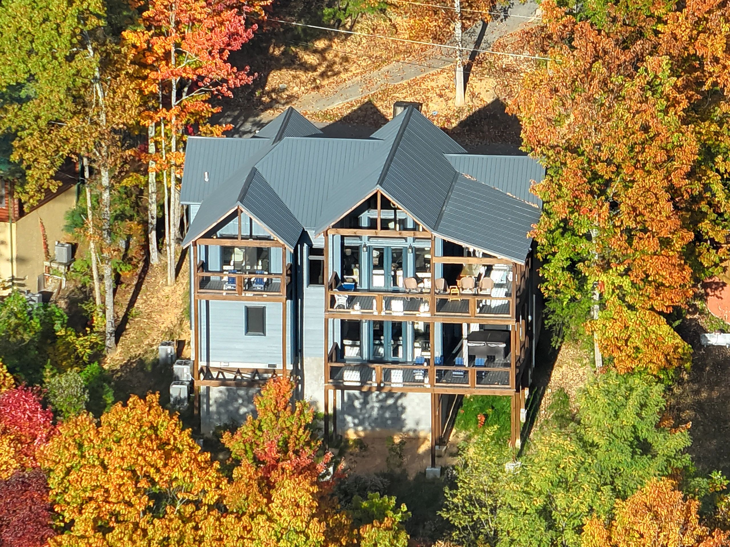 A large house surrounded by colorful autumn trees.