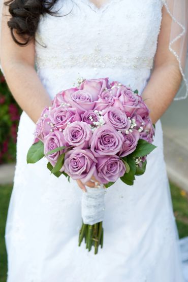 Bride holding a bouquet of lavender roses.