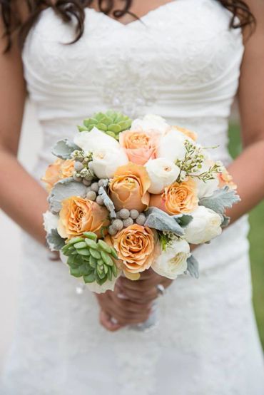 Bride holding white and peach rose bouquet.