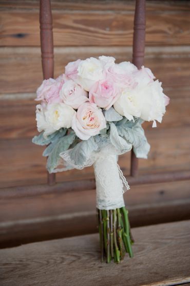 Bouquet of soft pink and white roses on a wooden chair.