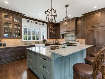Elegant kitchen with marble island and wooden cabinetry.