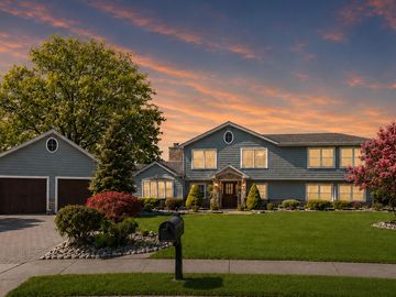 Beautiful suburban house at sunset with a lush green lawn.