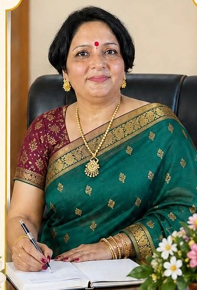 Woman in traditional saree writing in a notebook, smiling warmly.