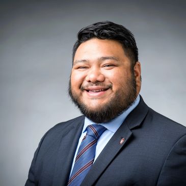 Smiling man in a suit and tie posing for a professional portrait.