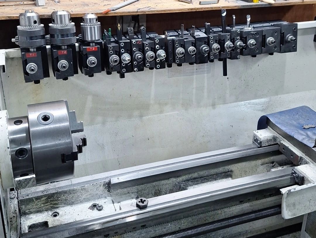 Metal lathe machine with tool holders above.