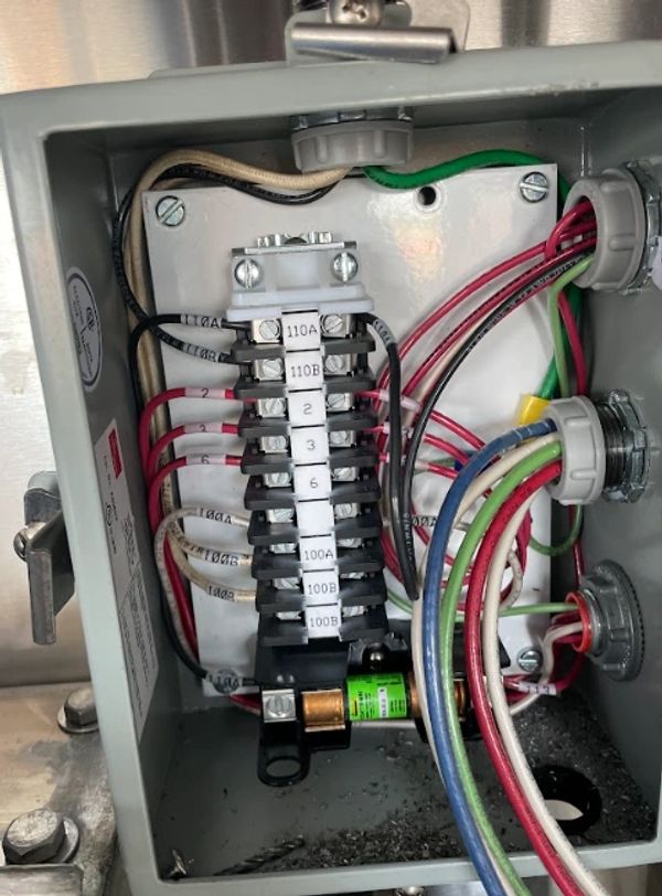 Open electrical junction box with organized wiring and labeled terminals.