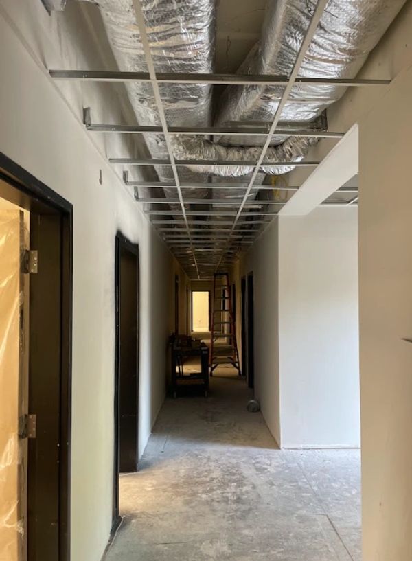 Hallway under construction with exposed ceiling ducts and framework.
