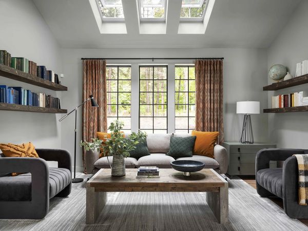 Cozy living room with neutral tones, comfortable seating, and natural light from skylights.