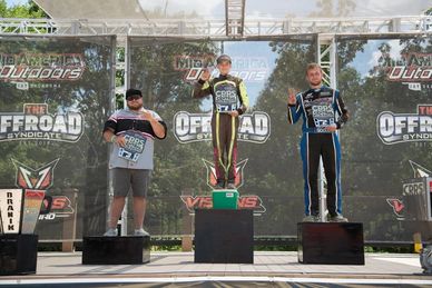 Cash is on the podium at Mid America Outdoors on the first place spot- standing on a cooler 