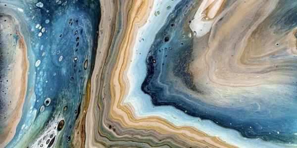 Various colors of blue and brown and green in agate swirling together in a large ripple like water