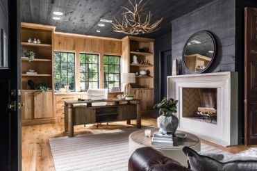 Cozy wooden home office with fireplace and natural light.