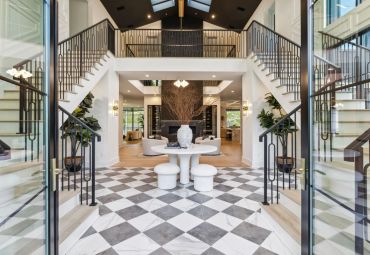 Elegant modern foyer with double staircase and checkered floor.